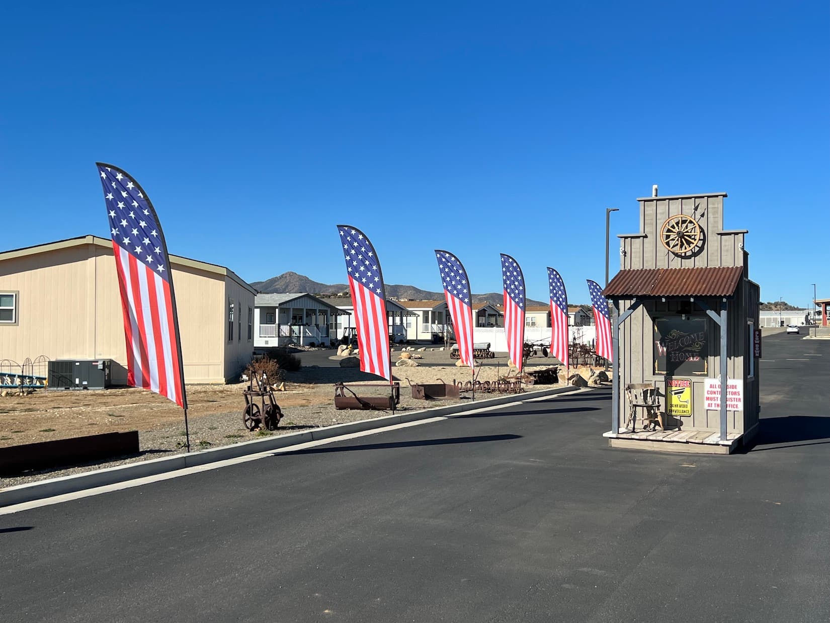 The welcome entrance at Orchard Ranch North Resort lined with American flags.